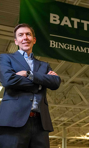 Paul Malliband, Executive Director of Battery-NY, looks off into distance as though into the future, set in industrial space meant for future battery technology and manufacturing prototyping.